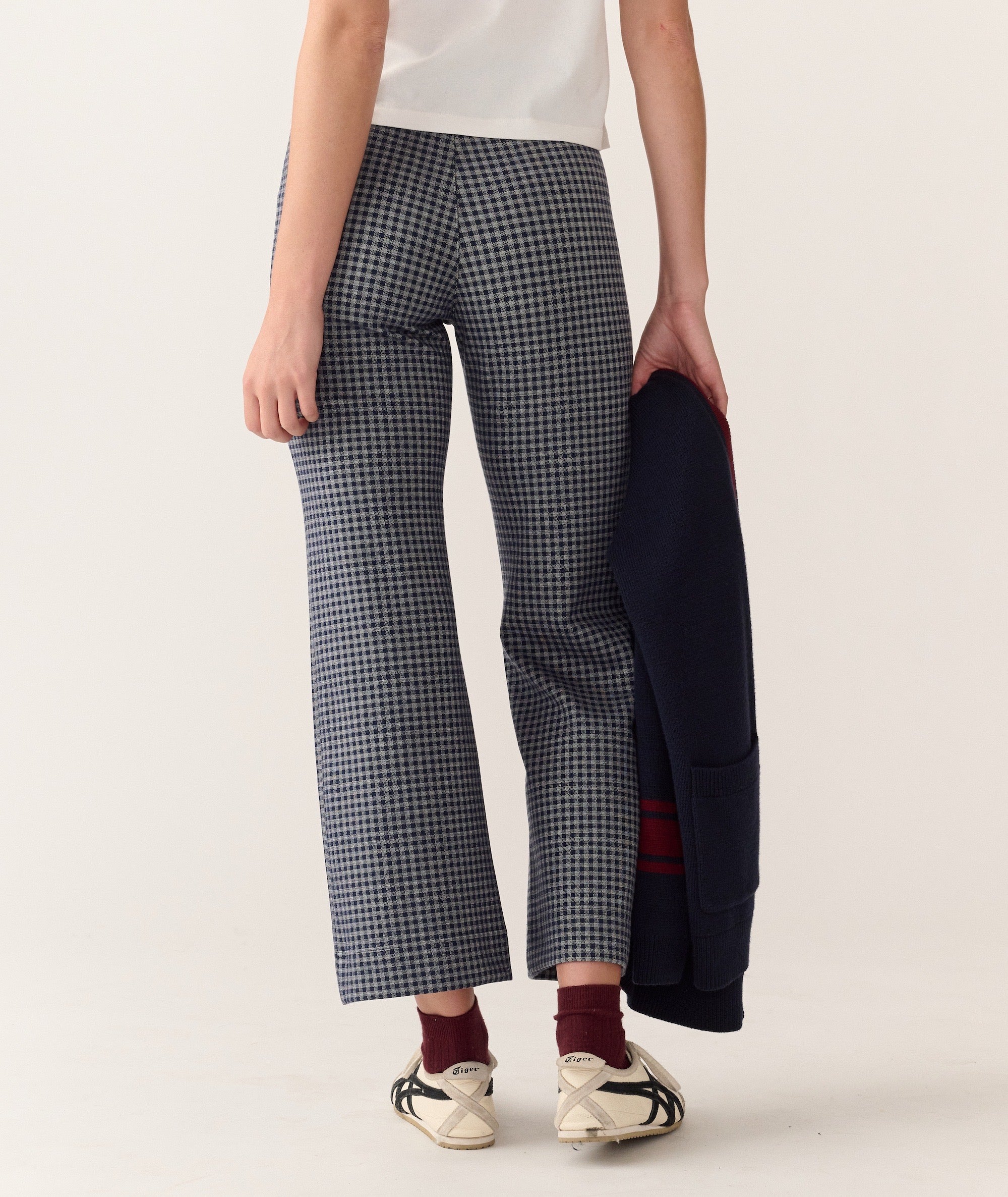 Back view of the Bobbi Flare Pant in a blue and white checkered pattern, worn with sneakers and socks.
