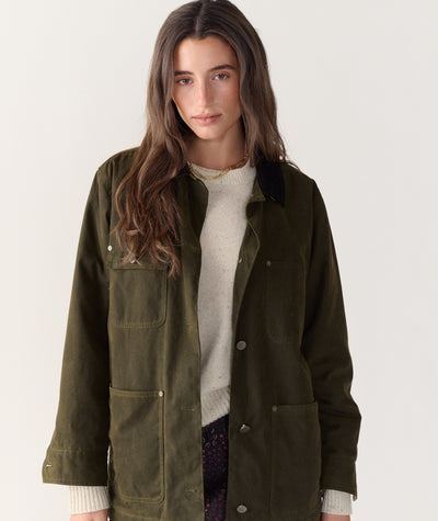 Model wearing the olive green Riley Barn Jacket, featuring a corduroy collar and front pockets.