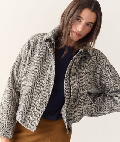 Model wearing the Chelsea Herringbone Bomber in grey, featuring a textured herringbone pattern and zipper.