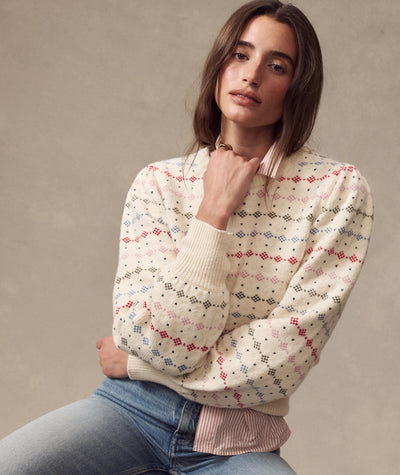 Model wears the cream Alma Puff Sleeve Sweater with a colorful fair isle pattern over a striped shirt.