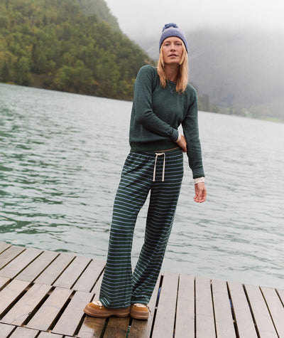 Model wears Double Knit Wide Leg Pant in dark green stripes, styled with a matching sweater on a dock.