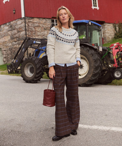 Model wears brown plaid Allison Pleated Moleskin Trouser with a fair isle sweater and loafers.