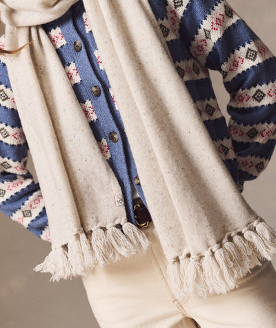 Model wearing the Coastal Merino Long Scarf in cream with speckled texture and fringe detail.