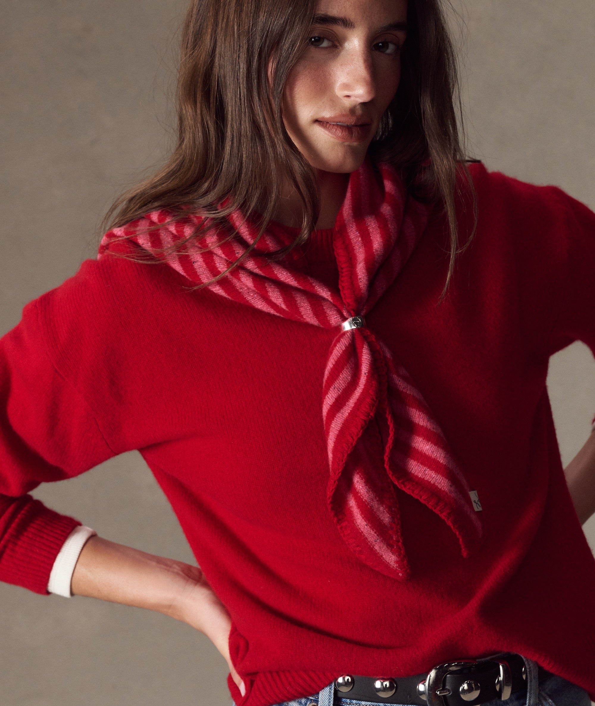 Model wears a red and pink striped Coastal Merino Triangle Scarf secured with a silver ring.