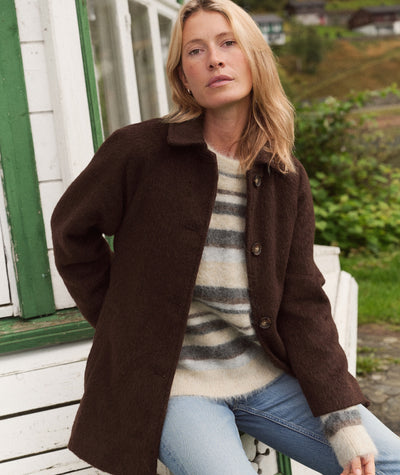 Model wears the brown Esme Wrap Coat over a striped sweater and jeans, showing a front view.