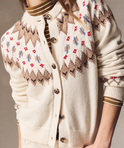 Model wearing a cream Fiorella Fair Isle Cardigan with brown, red, and blue patterns and button front.
