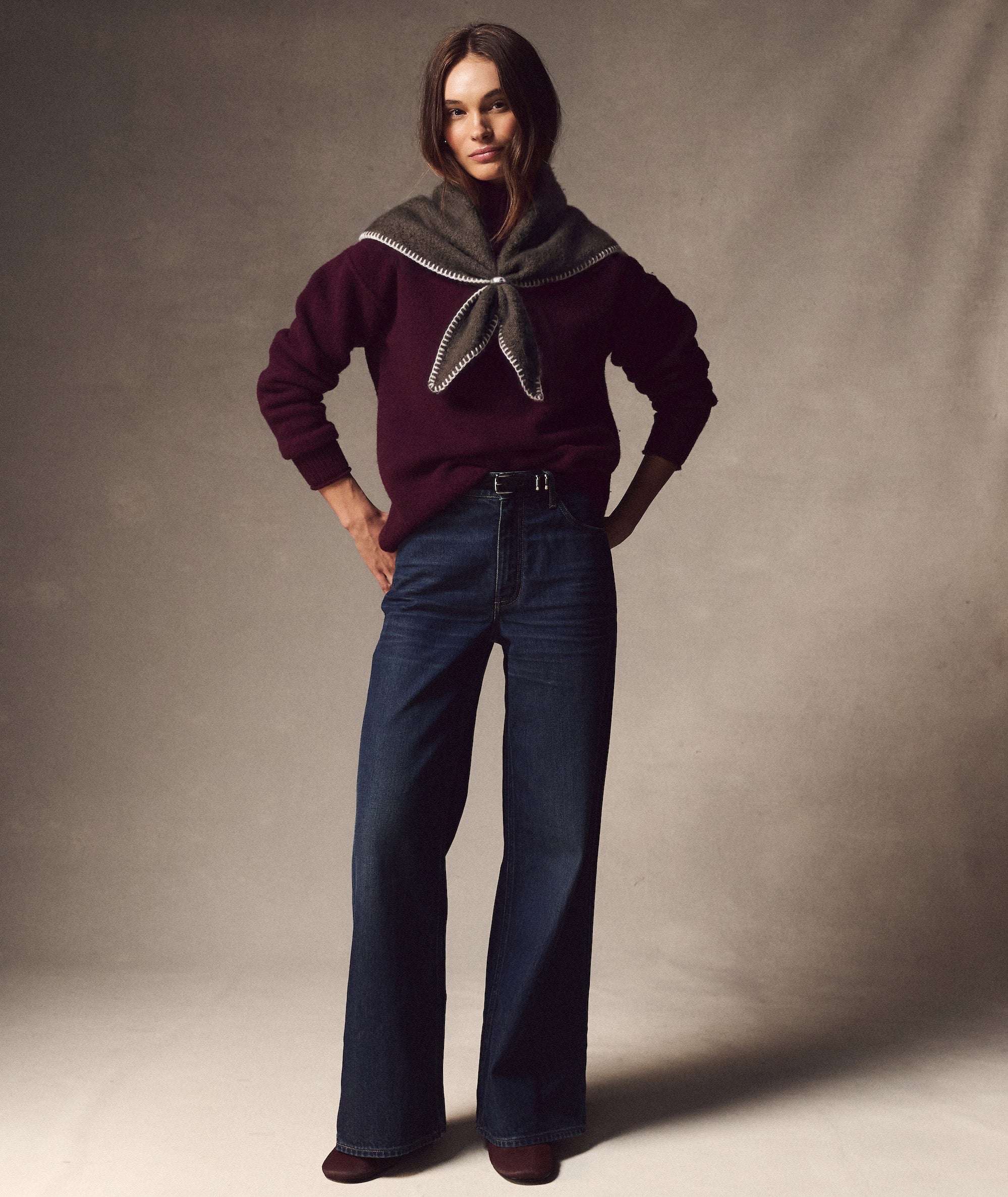 Model wearing a charcoal Knit Bandana with white whipstitch detail, styled over a burgundy sweater.