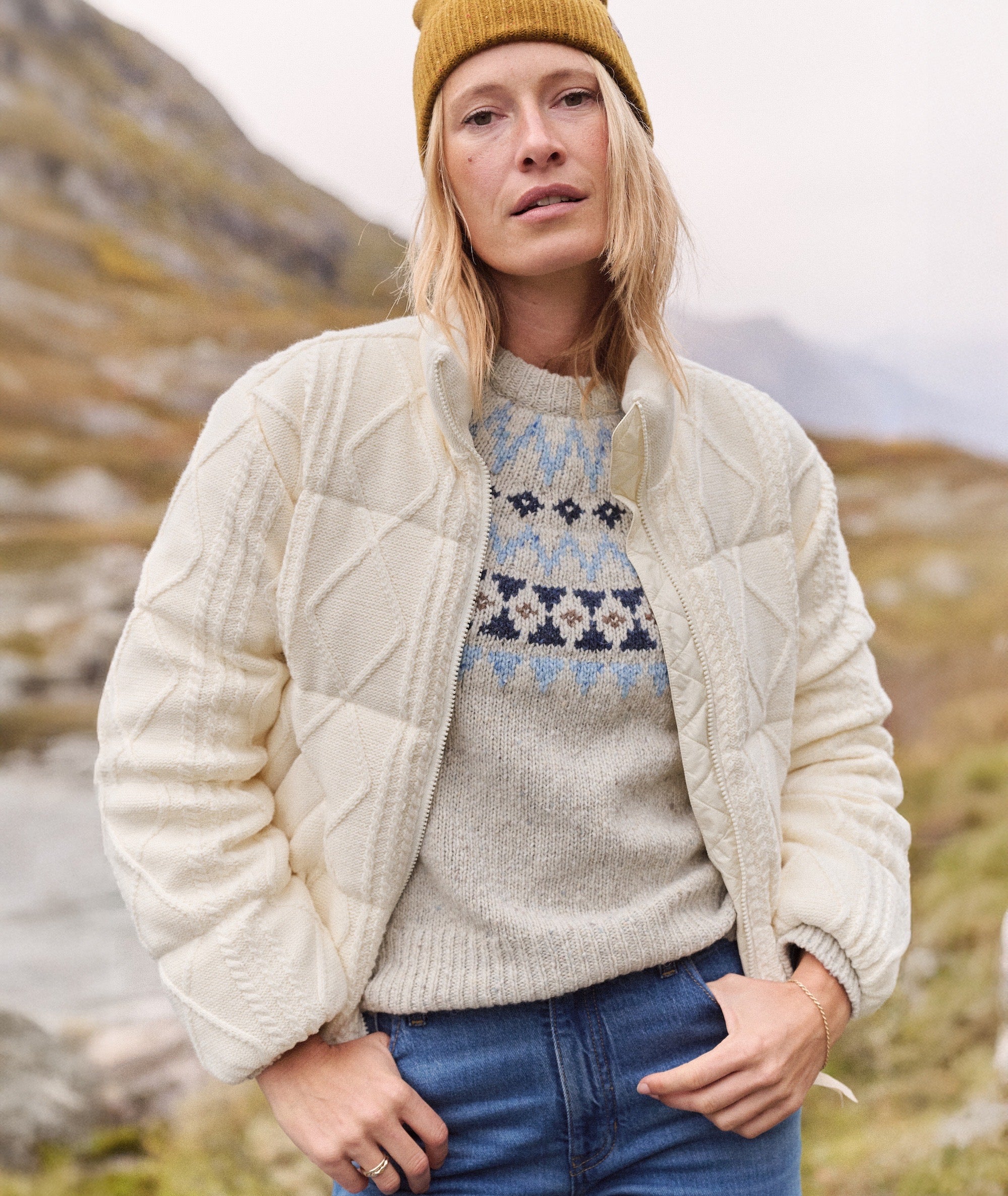 Model wearing cream Shea Sweater Puffer Jacket with cable-knit texture over a patterned sweater.