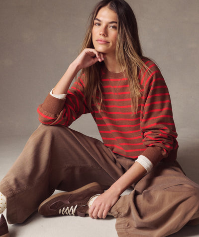 Model wearing the brown and red striped Cloud 9 Fleece Reversible Crewneck with brown pants.